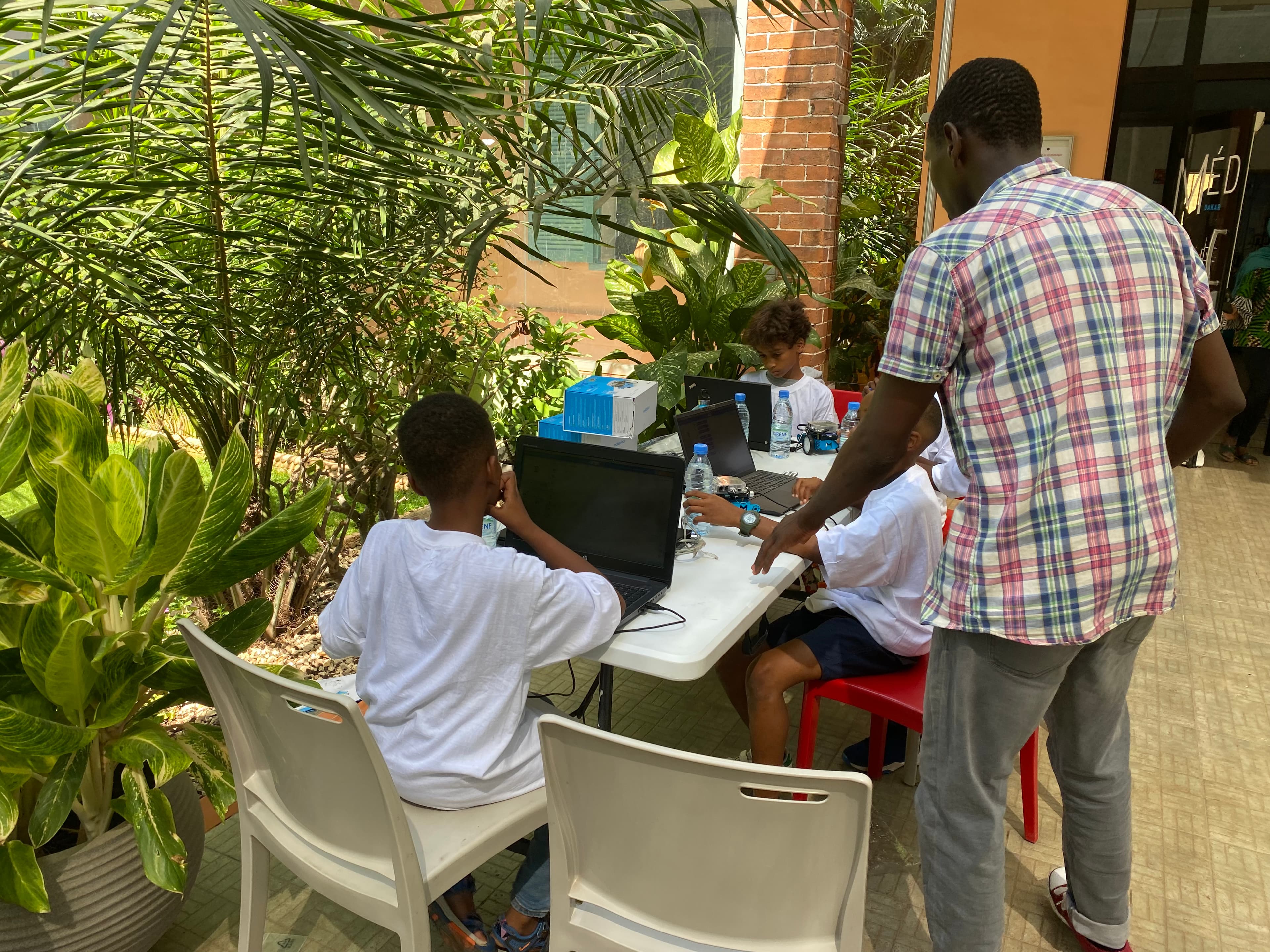 Un mentor Ashita encadre un atelier robotique et programmation sur ordinateur